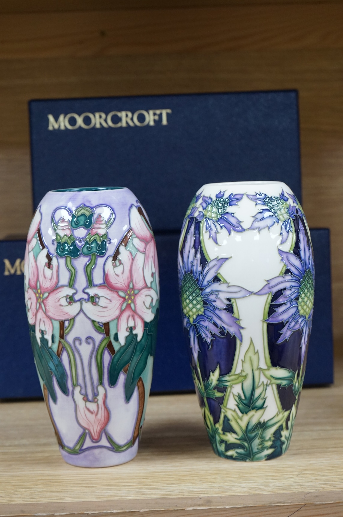 Two Moorcroft vases, Blakeney and a Caledonia patterns, both boxed, 18.5cm